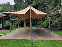 Grâce aux poteaux en bois et les couleurs neutres, la tente s'intègre parfaitement à l'environnement