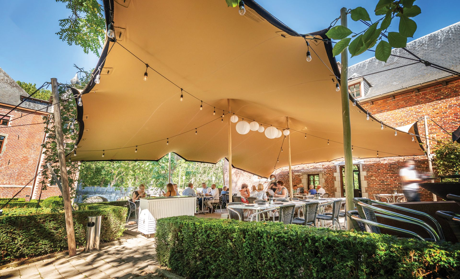 Une tente extensible de couleur chino tendue au-dessus d'une terrasse