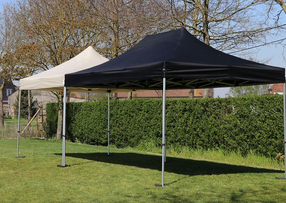 Tente pliante beige et noire installée dans le jardin